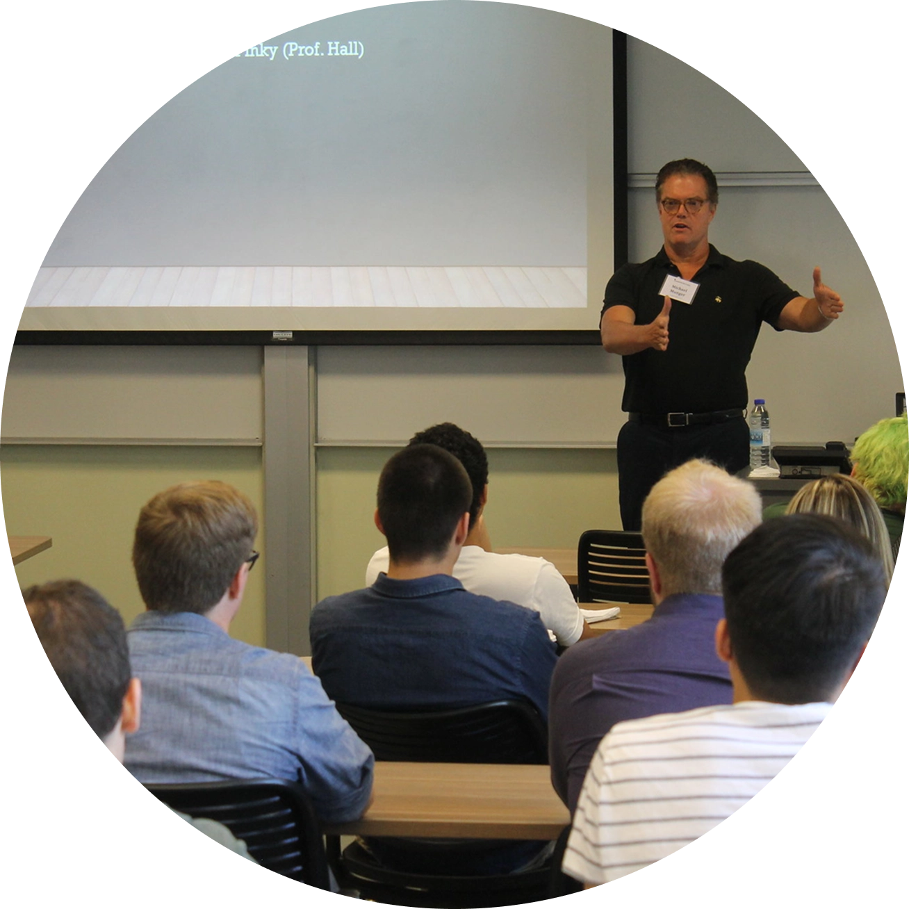 A speaker addresses an audience in a classroom