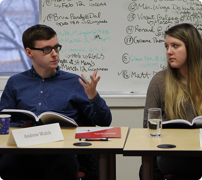 Two students or panelists at desks